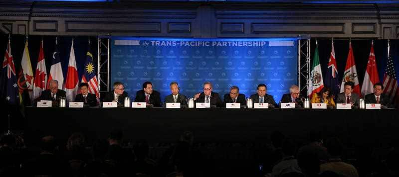 Delegates from 12 countires front the media after signing the Trans-Pacific Partnership free trade pact.