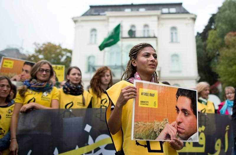 Ensaf Haidar, wife of the imprisoned Saudi Arabian blogger, Raif Badawi, holds a sign reading '#FreeRaif'.