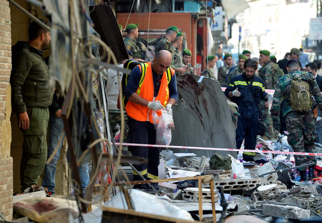 Members of the Lebanese police forces and Hezbollah inspect the site of a twin suicide attack in the Bourj al-Barajneh suburb of Beirut. (EPA)