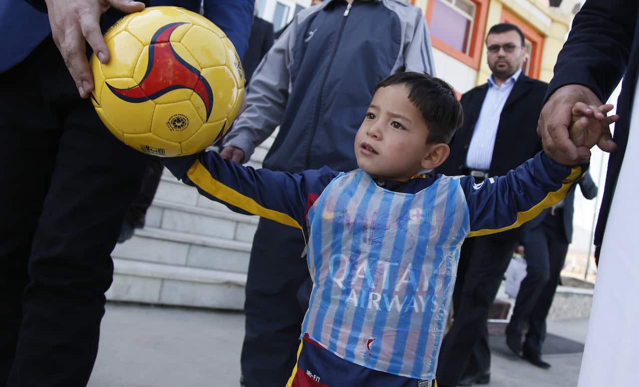 Five-year-old Afghan boy Murtaza Ahmadiwho wearing a striped plastic bag resembling the Argentinian soccer star's national team jersey.