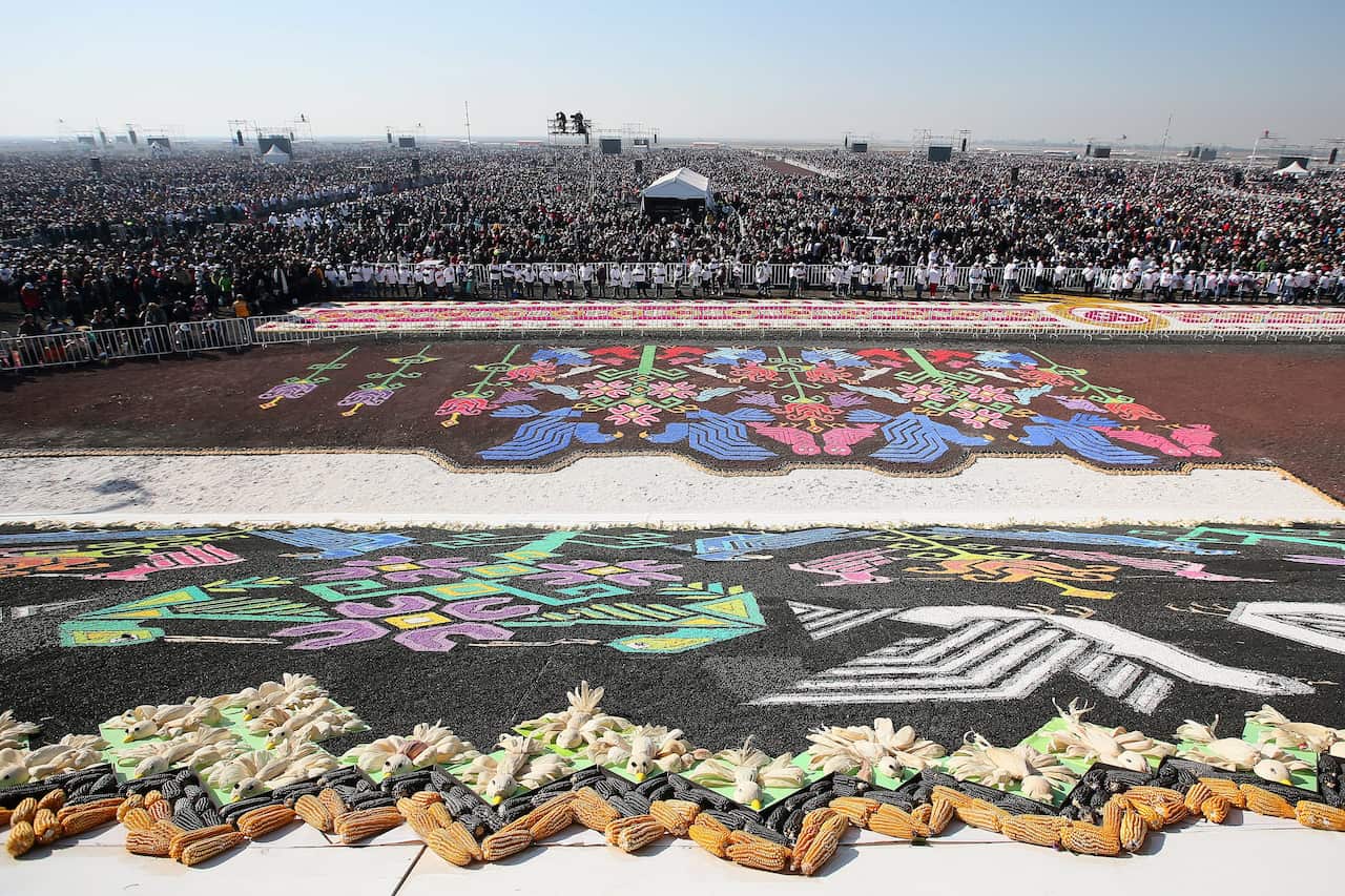 Catholics gather in their thousands before the mass 