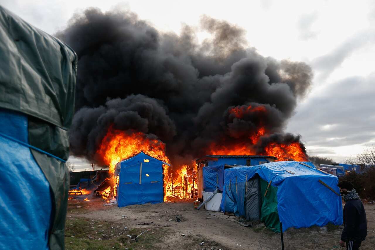 A burning shelter at the start of the demolition of a part of the Jungle migrant camp in Calais, France, 29 February 2016.