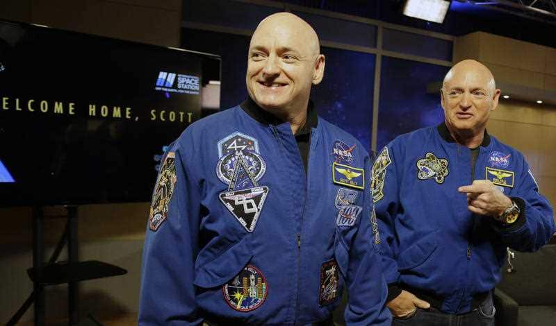 NASA astronaut Scott Kelly, left, and his twin Mark get together before a press conference.