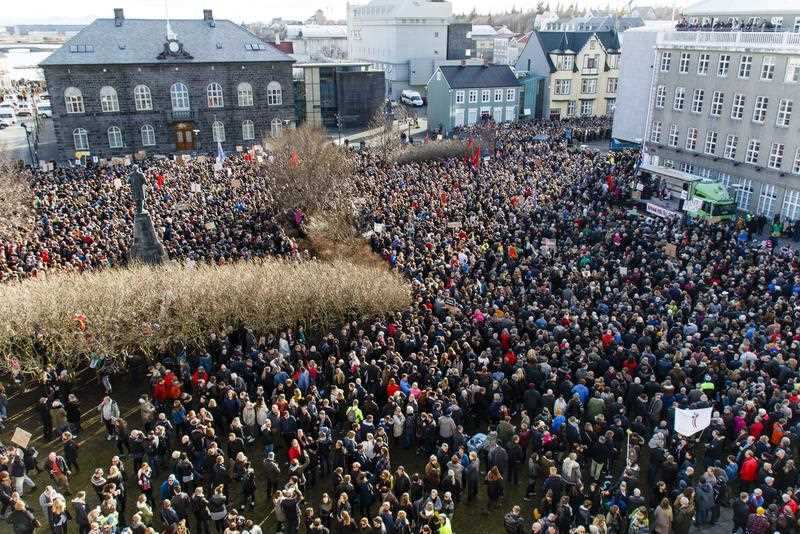 People gather during a protest on Austurvollur Square in front of the Icelandic Parliament in Reykjavik calling for the resignation of the PM.