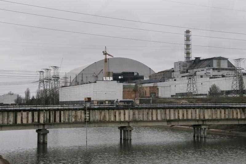 The old sarcophagus, right, over the reactor building damaged by explosion and a new confinement, left, under construction at the Chernobyl nuclear power plant.