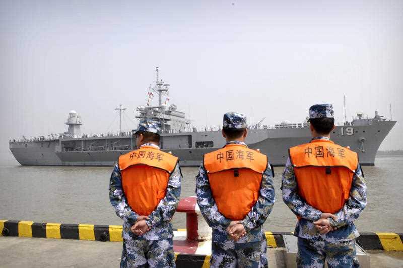 Soldiers from the Chinese People's Liberation Army (PLA) Navy watch as the USS Blue Ridge arrives at a port in Shanghai, Friday, May 6, 2016