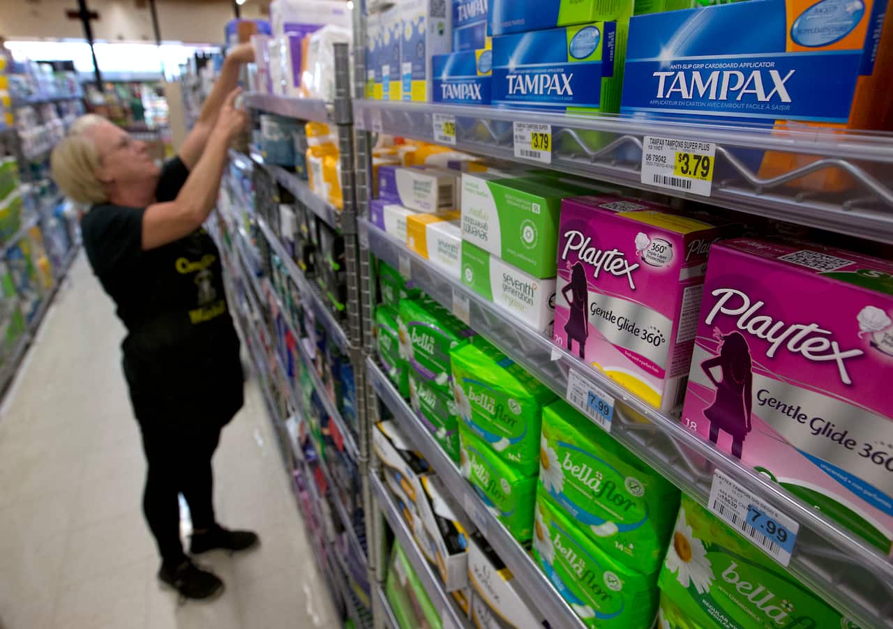 Feminine hygiene products are restocked at a supermarket. 
