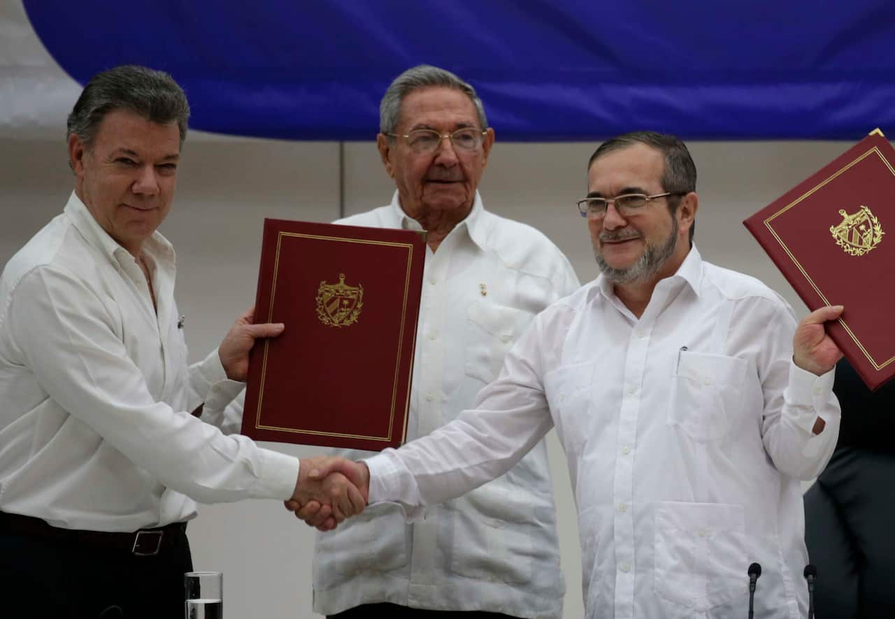 Colombian President Juan Manuel Santos, left, Cuba's President Raul Castro, center, and Commander of the FARC, Timoleon Jimenez pose for a photo