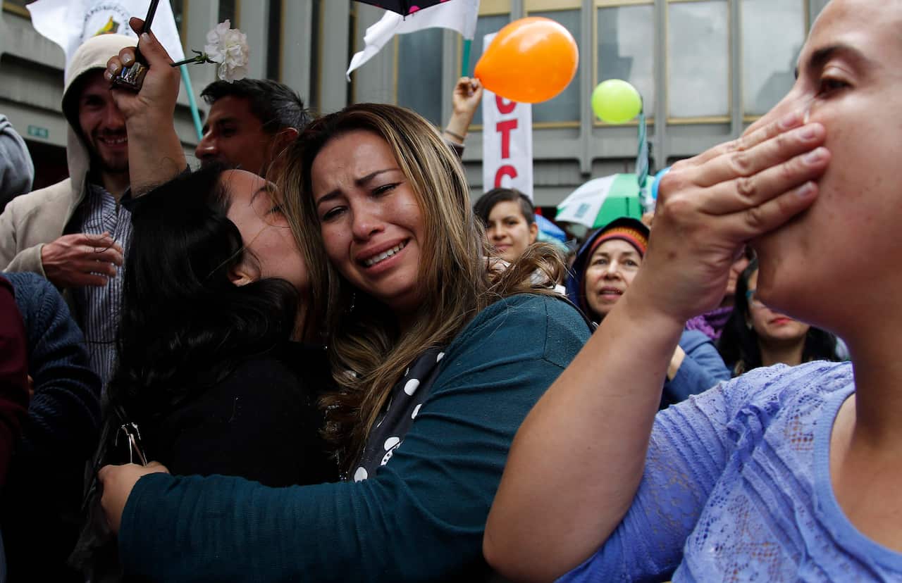 People celebrate the agreement between Revolutionary Armed Forces of Colombia, FARC, and Colombia's government, in Bogota, Colombia, Thursday, June 23, 2016. 