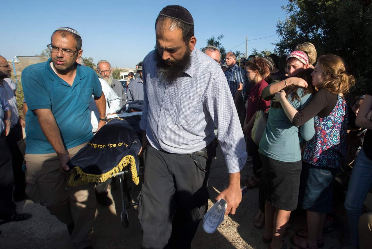 Friends embrace as the body of 13-year-old Israeli girl Hillel Yaffe Ariel is brought to the family home before her funeral service