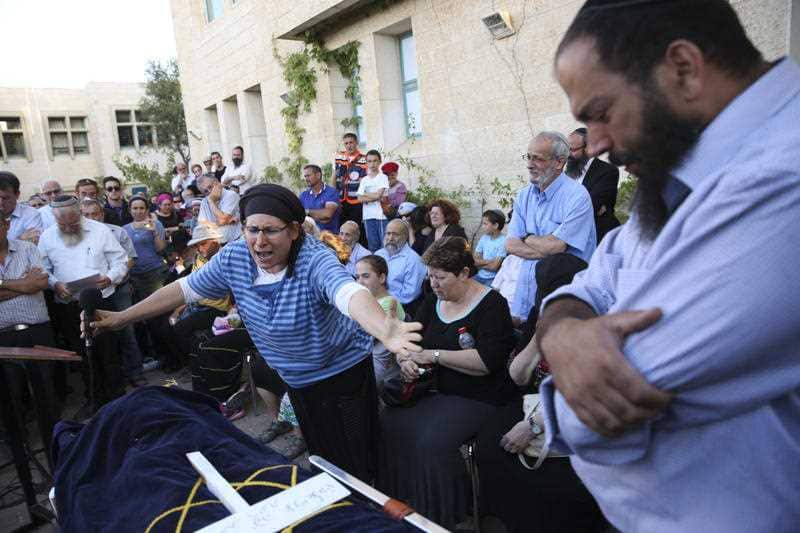 Rina Ariel weeps over the body of her slain 13 year old daughter Hallel during her funeral inside a Jewish settlement of Kiryat Arba, West Bank, Thursday, June 30, 2016.