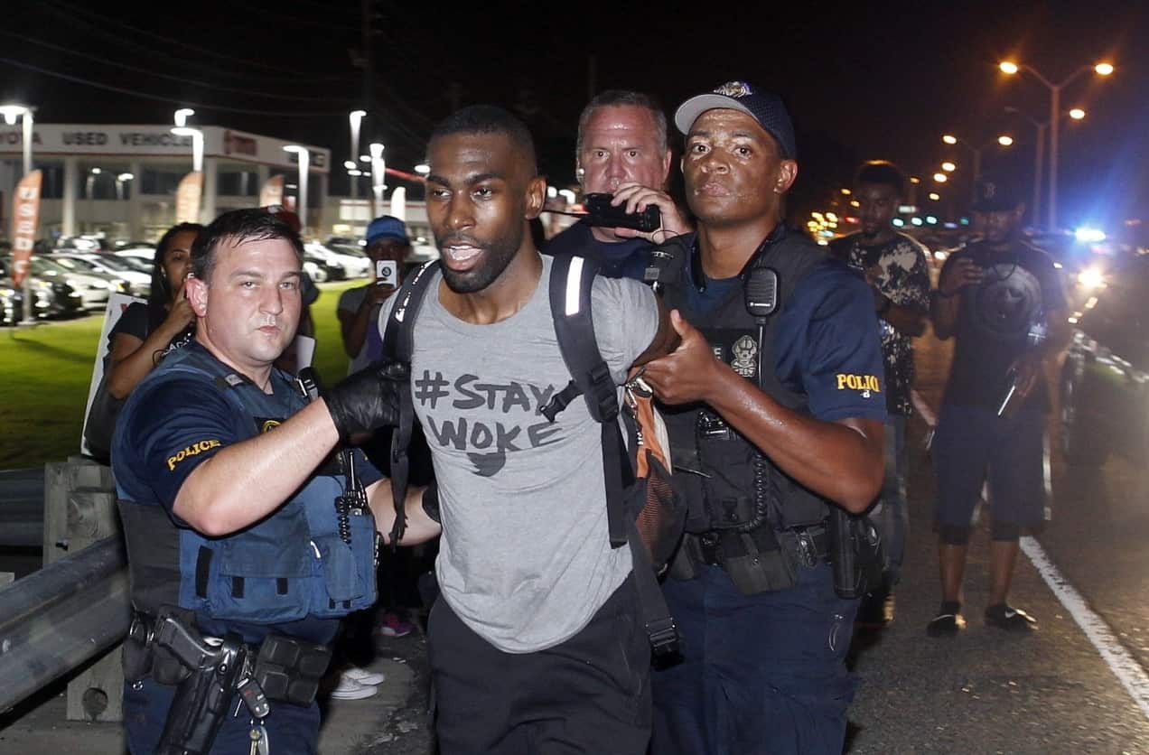 Police arrest activist DeRay McKesson during protest along Airline Highway, a major road that passes in front of the Baton Rouge Police Department headquarters