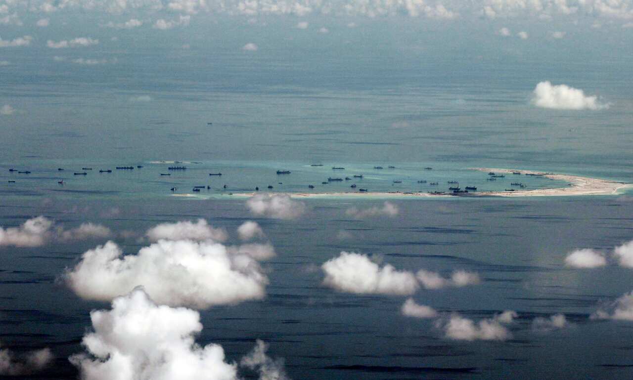 boats seen from the sky near a sliver of land in the south china sea.