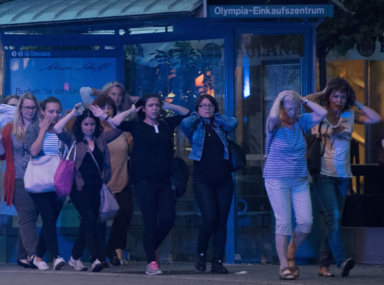 People leave the Olympia mall in Munich, southern Germany, Friday, July 22, 2016 after several people have been killed in a shooting. (AP Photo/Sebastian Widmann)
