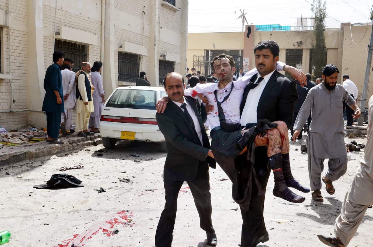 People shift an injured lawyer at the scene of a bomb blast in restive Quetta, Pakistan, 08 August 2016