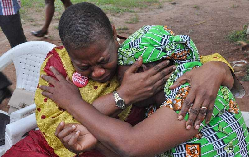 Obiageli Ezekwesili, left, consoles Esther Yakubu, mother of one of the kidnapped school girls, after she saw her daughter in a new video released by Boko Haram