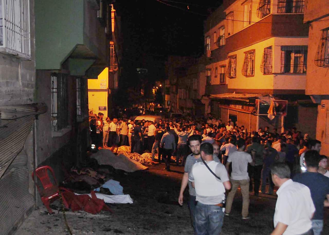People gather after an explosion in Gaziantep, southeastern Turkey, early Sunday, Aug. 21, 2016. Gaziantep Province Gov. Ali Yerlikaya said the deadly blast, during a wedding near the border with Syria, was a terror attack. (Eyyup Burun/DHA via AP)e