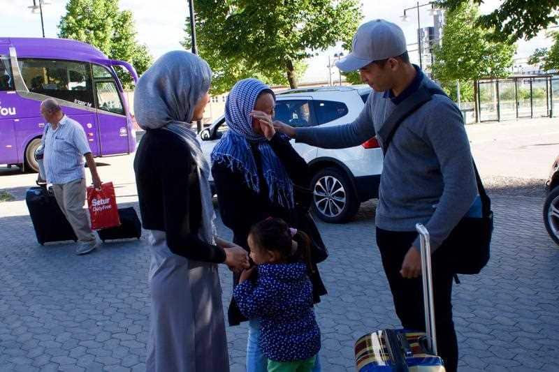 Mahdi Azizi wipes a tear from his mother's eye prior to him boarding a bus to return to a centre for unaccompanied minors, in Vasteras, Sweden.