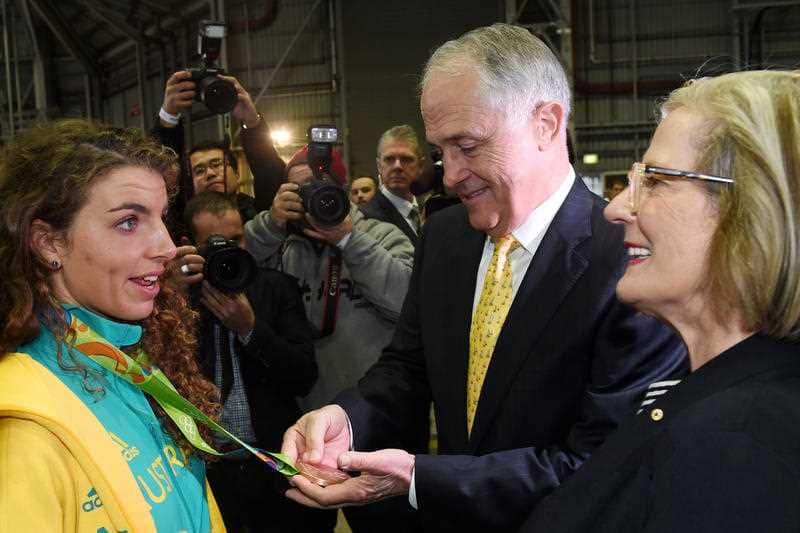 Prime Minister Malcolm Turnbull looks at the bronze medal of Australian Olympic team member Jessica Fox (left) as she speaks with Lucy Turnbull.