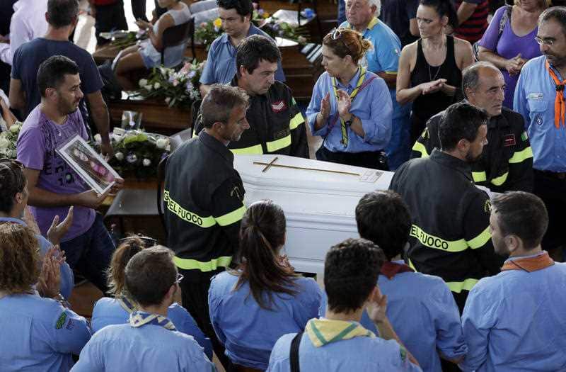 The coffin of 9-year-old Giulia Rinaldo, is carried outside the gymnasium at the end of the state funeral service in Ascoli Piceno, Italy