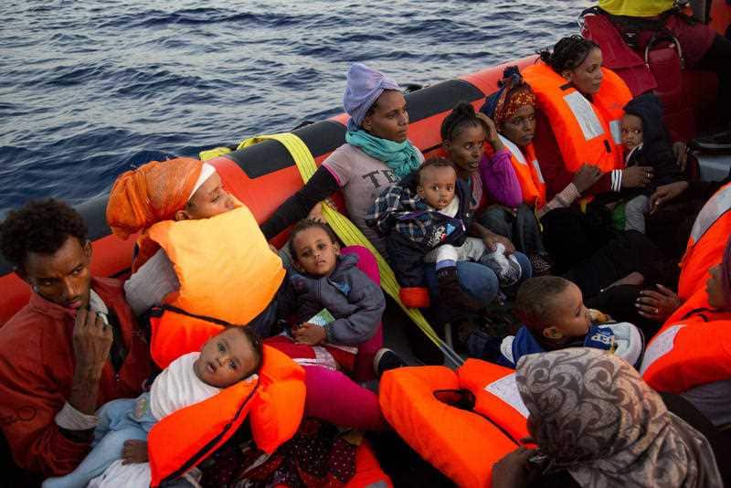 Migrants from Eritrea hold their children after been rescued from a crowded wooden boat as they were fleeing Libya