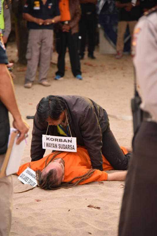 British man David Taylor reenacts a scene on Kuta beach with a police officer posing as alleged murder victim Wayan Sudarsa, Kuta Beach, Bali