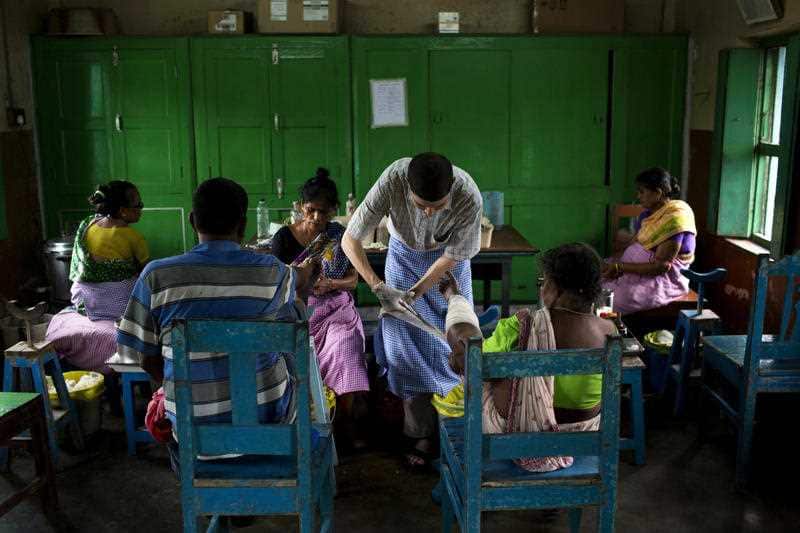 Alex Blum, a volunteer from Maryland, U.S., dresses a patient at the Gandhiji Prem Nivas, or Gandhiji House of Love, in Titagarh, north of Kolkata, India
