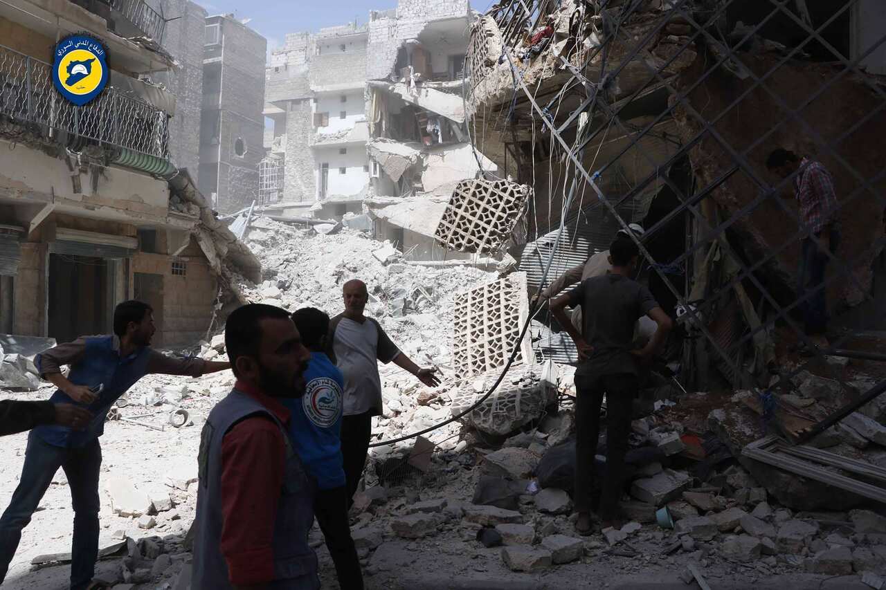 Men stand amid rubble after airstrikes in al-Mashhad neighborhood in the rebel-held part of eastern Aleppo, Wednesday Sept. 21