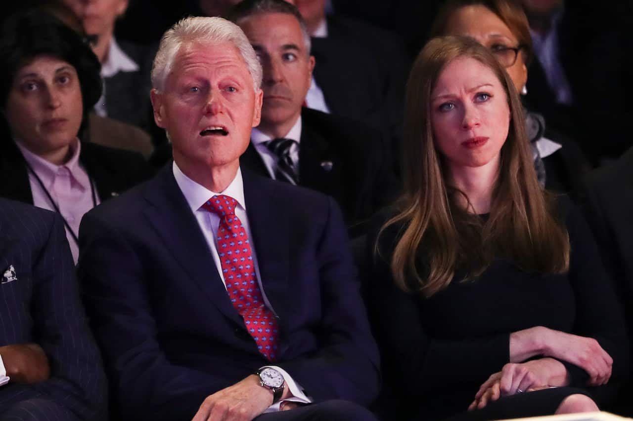 Former President Bill Clinton and Chelsea Clinton, daughter of Hillary Clinton listen during the presidential debate