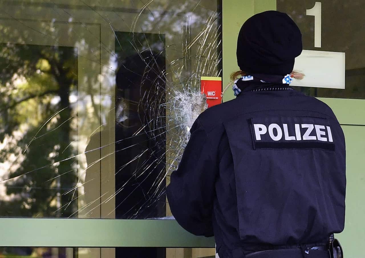 A police officer seals the damaged front door of a residential property in a housing estate in the Yorck area of Chemnitz, Germany, 09 October 2016. 