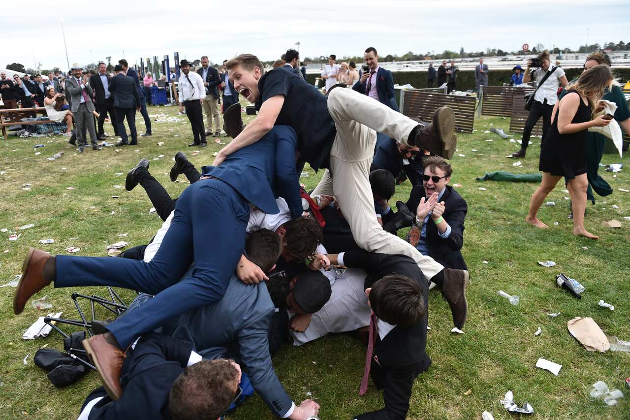Racegoers enjoy the atmosphere on the public lawn on Caulfield Cup Day at Caulfield Racecourse in Melbourne, Saturday, Oct. 15, 2016. (AAP Image/Julian Smith) NO ARCHIVING, EDITORIAL USE ONLY