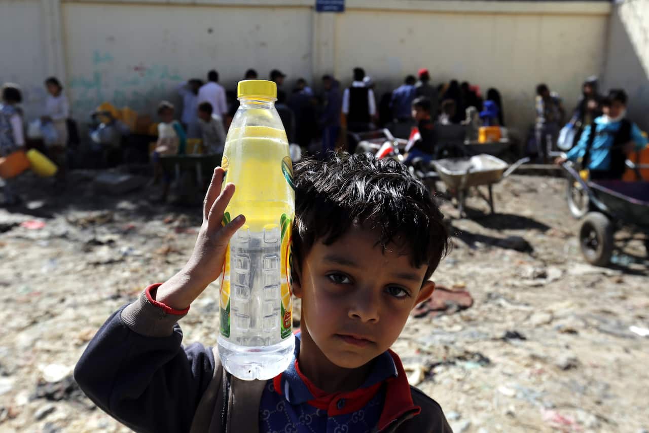 A young Yemeni carries a bottle filled with water from a donated source amid disruption of water supplies in Sana'a, Yemen, 28 October 2016.
