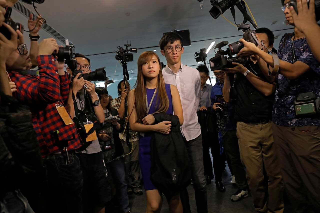 Newly elected Hong Kong lawmakers Yau Wai-ching, left, and Sixtus Leung, right, are surrounded by photographers outside legislature council camber after he tries to retake oath at legislature council in Hong Kong, Wednesday, Nov. 2, 2016. Two newly electe