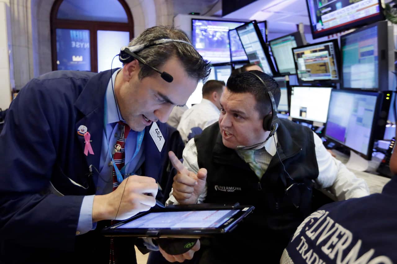 Traders Gregory Rowe, left, and Robert Finnerty work in their booth on the floor of the New York Stock Exchange, Wednesday, Nov. 9, 2016. 