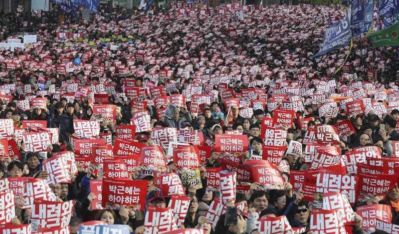 South Korean protesters hold up cards during a rally calling for South Korean President Park Geun-hye to step down in Seoul, South Korea
