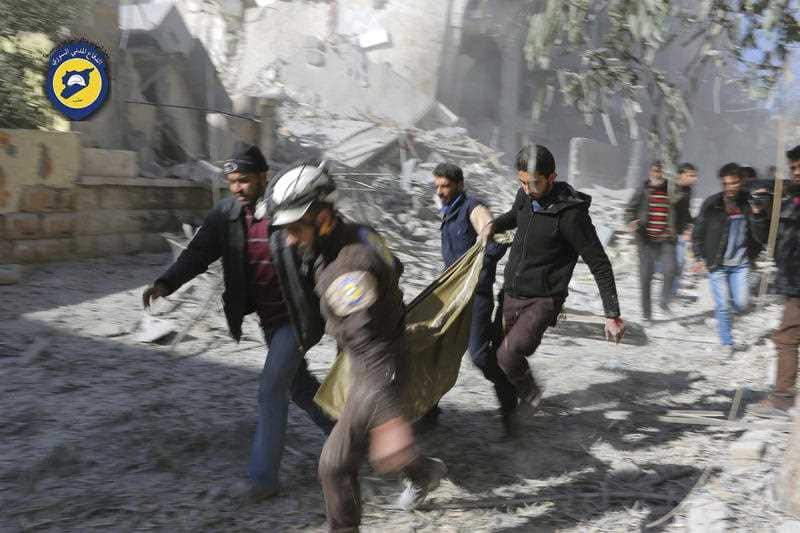 Civil Defense workers and Syrian citizens carry a dead body in the neighborhood of Seif al-Dawleh in Aleppo, Syria, Saturday, Nov. 19, 2016.