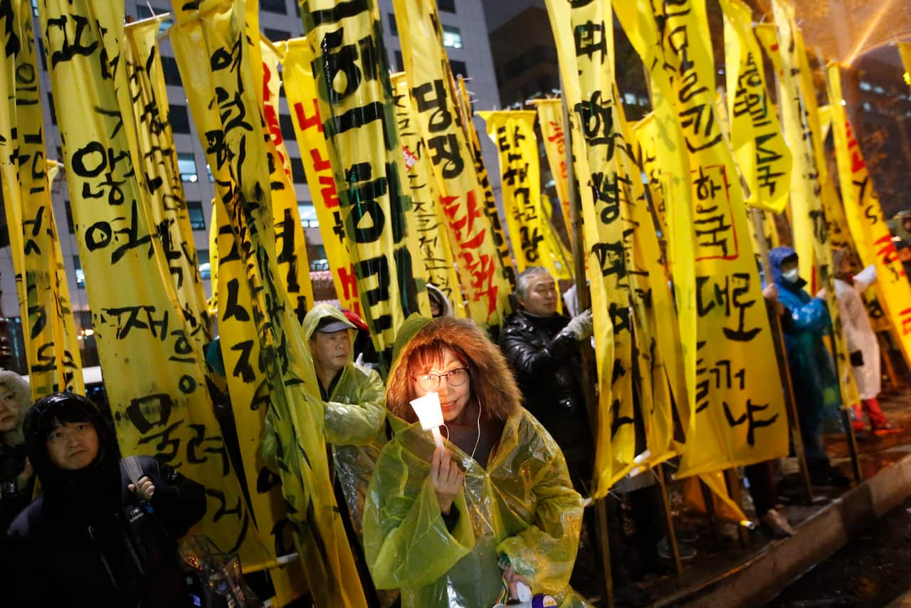 South Koreans march toward national assembly as they carry placards with text reading 'Park Geun-Hye Out'