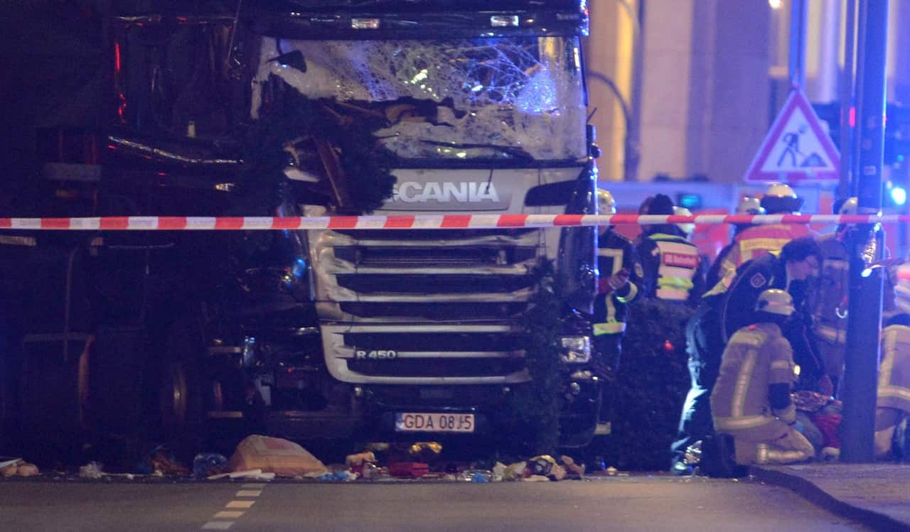 Rescue workers inspect the scenes and the truck that crashed into a Christmas market, close to the Kaiser Wilhelm memorial church in Berlin