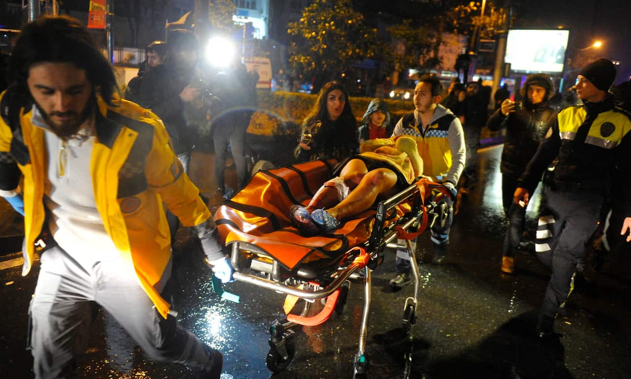 Medics carry a wounded victim on a stretcher to an ambulance after a gun attack on Reina, a popular night club in Istanbul