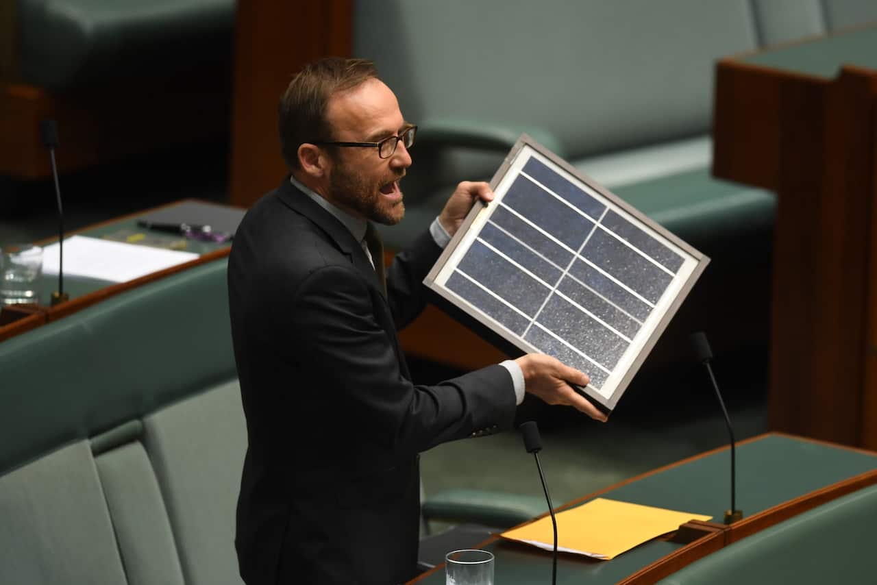 Australian Greens MP Adam Bandt speaks as he holds up a solar panel during House of Representatives Question Time at Parliament House in Canberra, Monday, Feb. 13, 2017. (AAP Image/Lukas Coch) NO ARCHIVING