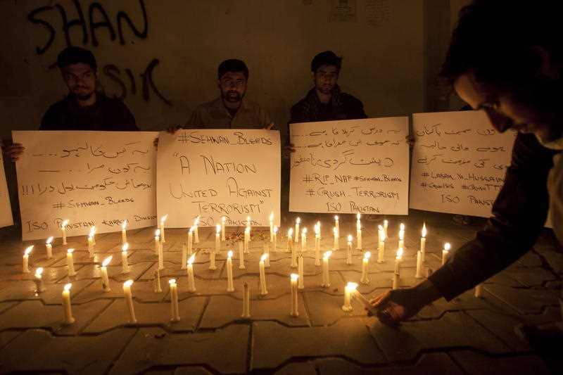 Pakistani students light candles to condemn the recent attack on a shrine in interior Sind province, Thursday, Feb. 16, 2017 in Karachi, Pakistan
