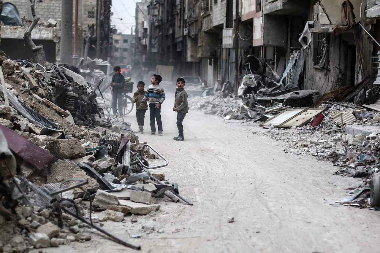 epa05821189 Children stand between the rubble, rebel-held Douma, Syria, 28 February 2017. The rubble are for buildings hit by airstrikes on 25 February 2017.  EPA/MOHAMMED BADRA