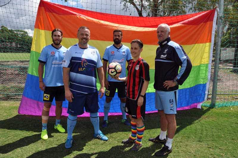 Members of A-League club Sydney FC posing for a photograph with a rainbow flag in 2017