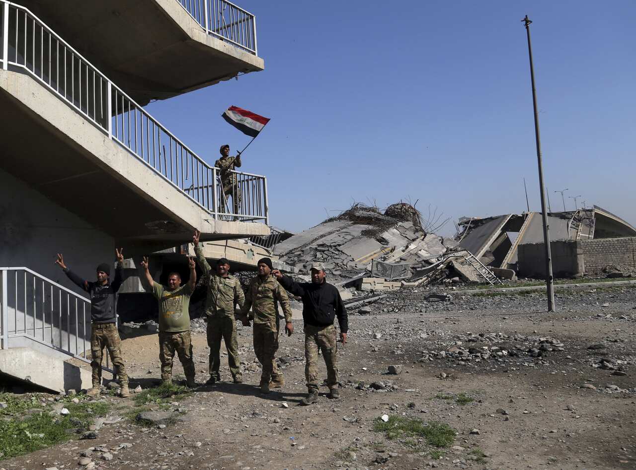  Iraqi soldiers celebrate on a bridge that they recently regained control of, from Islamic State militants, in western Mosul, Iraq, 