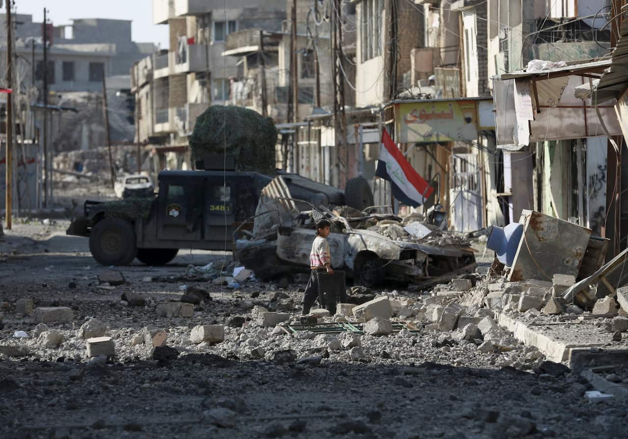  A boy walks among the debris of a damaged neighbourhood as Iraqi security forces advance during fighting against Islamic State militants in western Mosul.