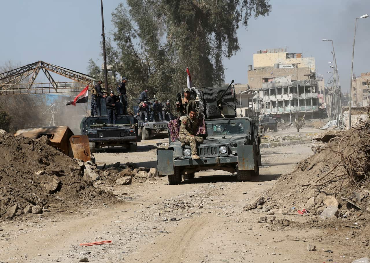 Iraqi security forces advance during fighting against Islamic State militants in western Mosul, Iraq.