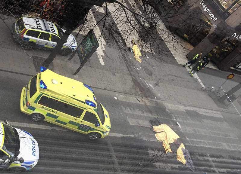 Members of the emergency services attend the scene after a truck crashed into a department store