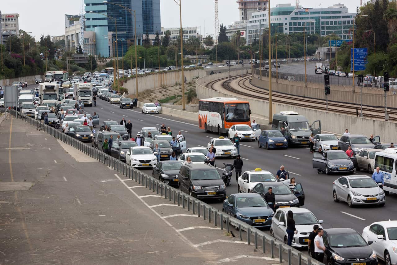 Israelis stand next to their cars as a siren sounds in memory of victims of the Holocaust in Tel Aviv, Israel.