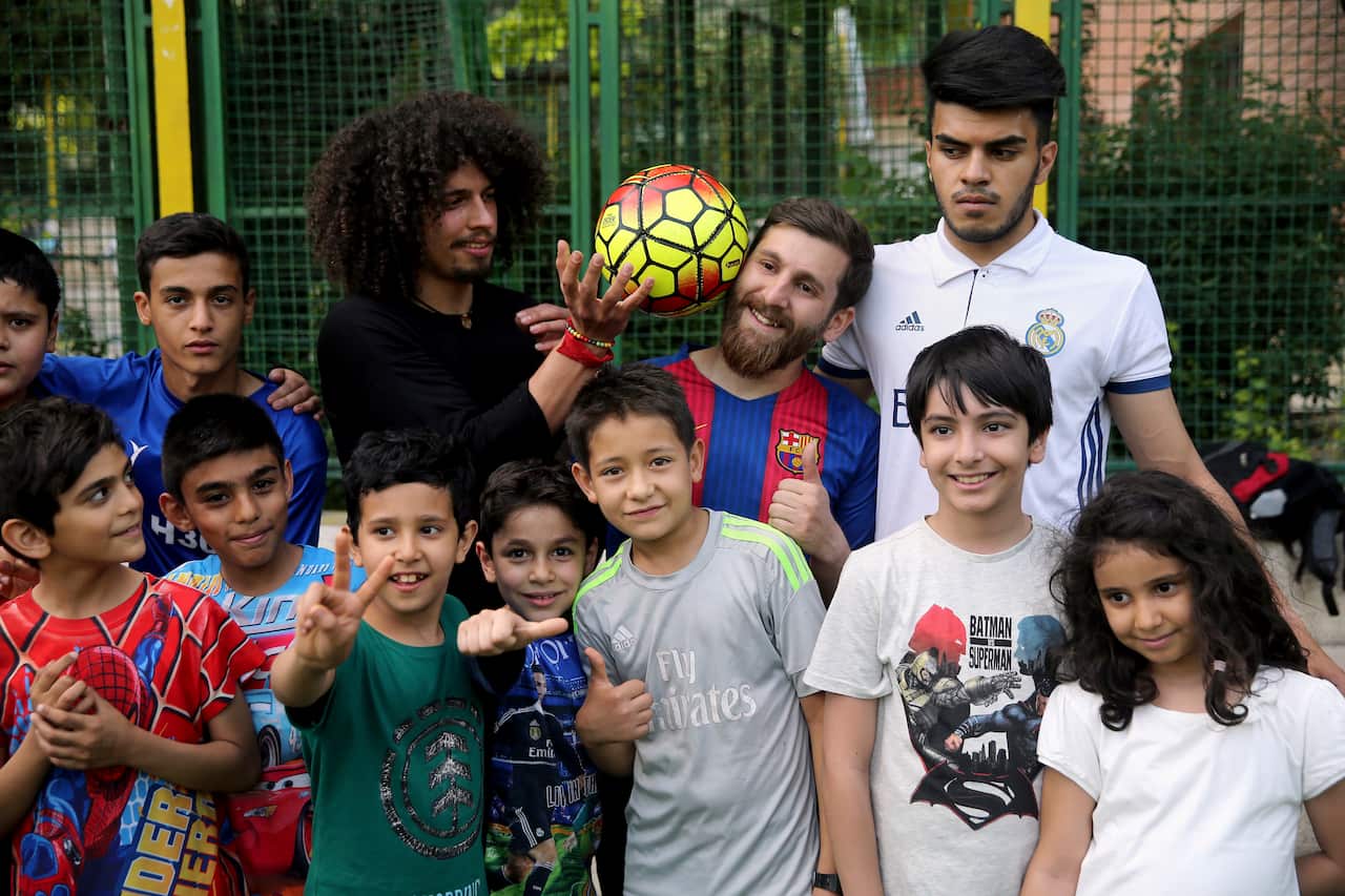 Iranians take a picture with Reza Parastesh, Iranian doppelganger of Lionel Messi, Argentinian soccer legend in Tehran, Iran.