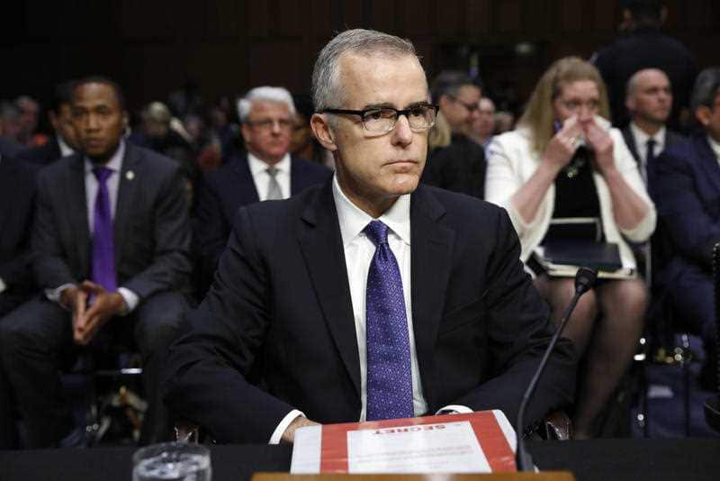 Acting FBI Director Andrew McCabe sits with a folder marked "Secret" in front of him while testifying on Capitol Hill in Washington